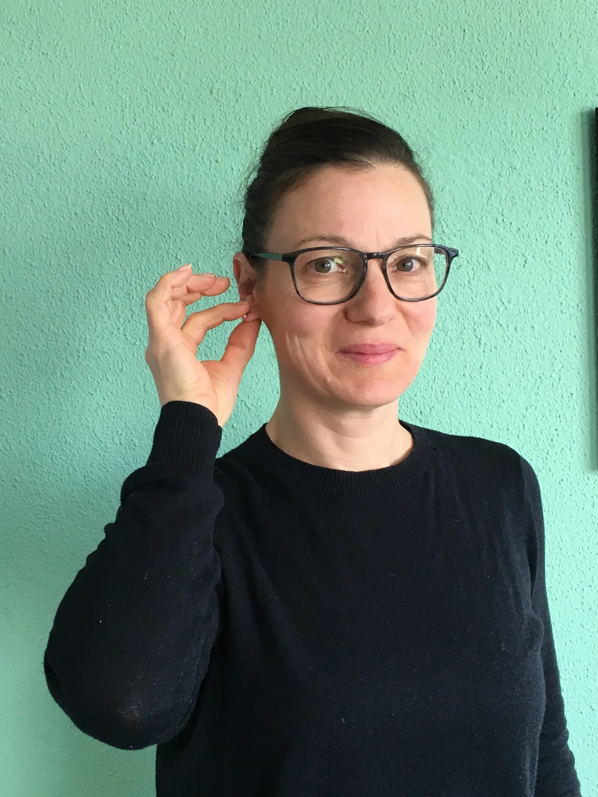 Man sieht eine Frau, die in Gebärdensprache ihren Namen mitteilt.